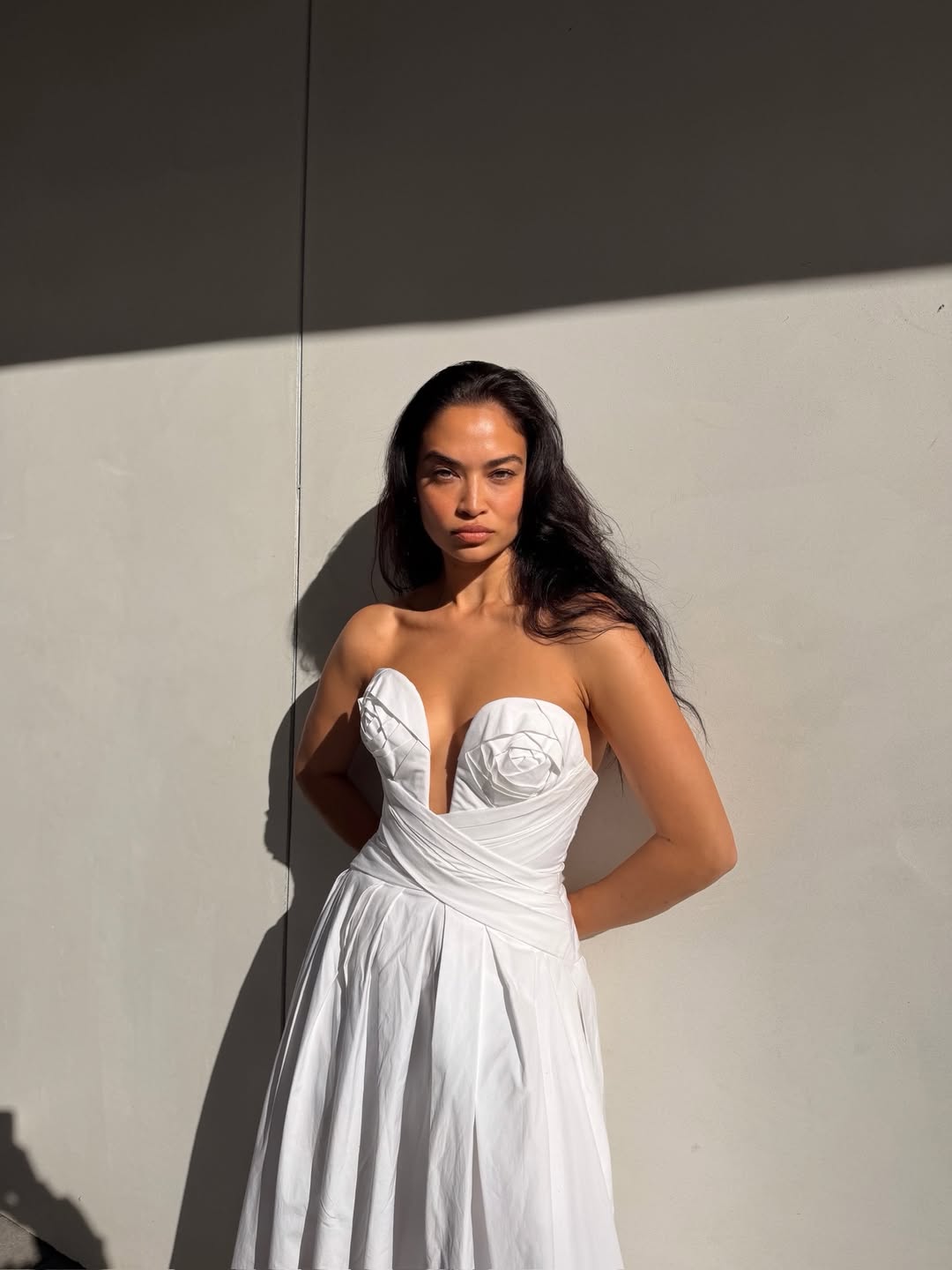 Shanina Shaik wearing a white strapless draped A line midi dress from Carolina Herrera Resort 2026