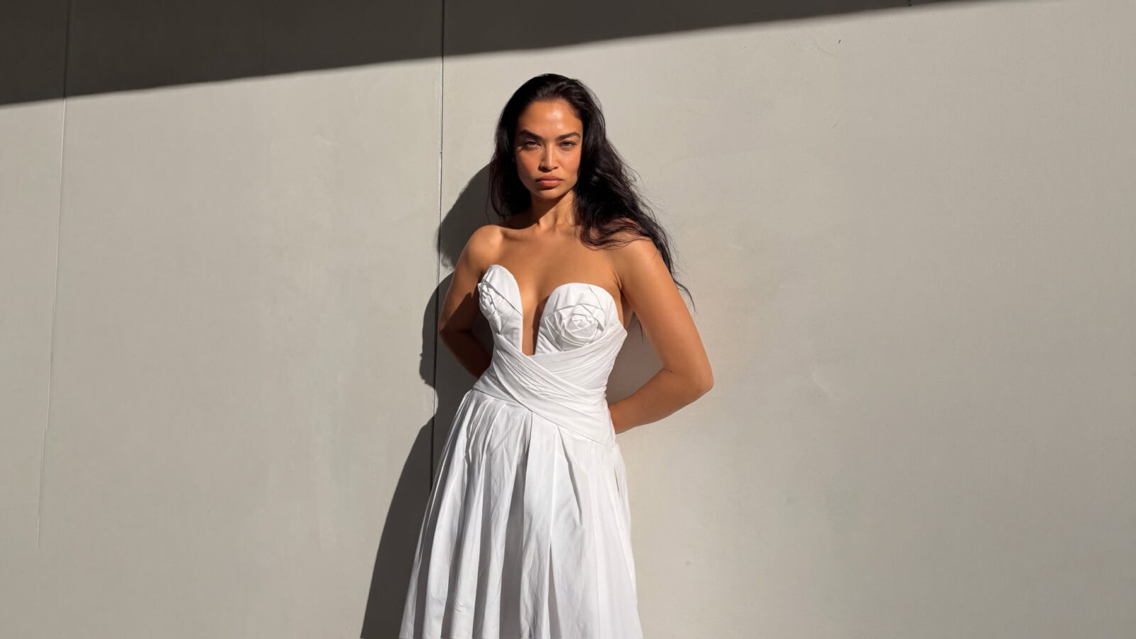 Shanina Shaik wearing a white strapless draped A line midi dress from Carolina Herrera Resort 2026