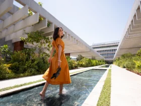 The Ned Doha garden pool exterior with woman in orange dress