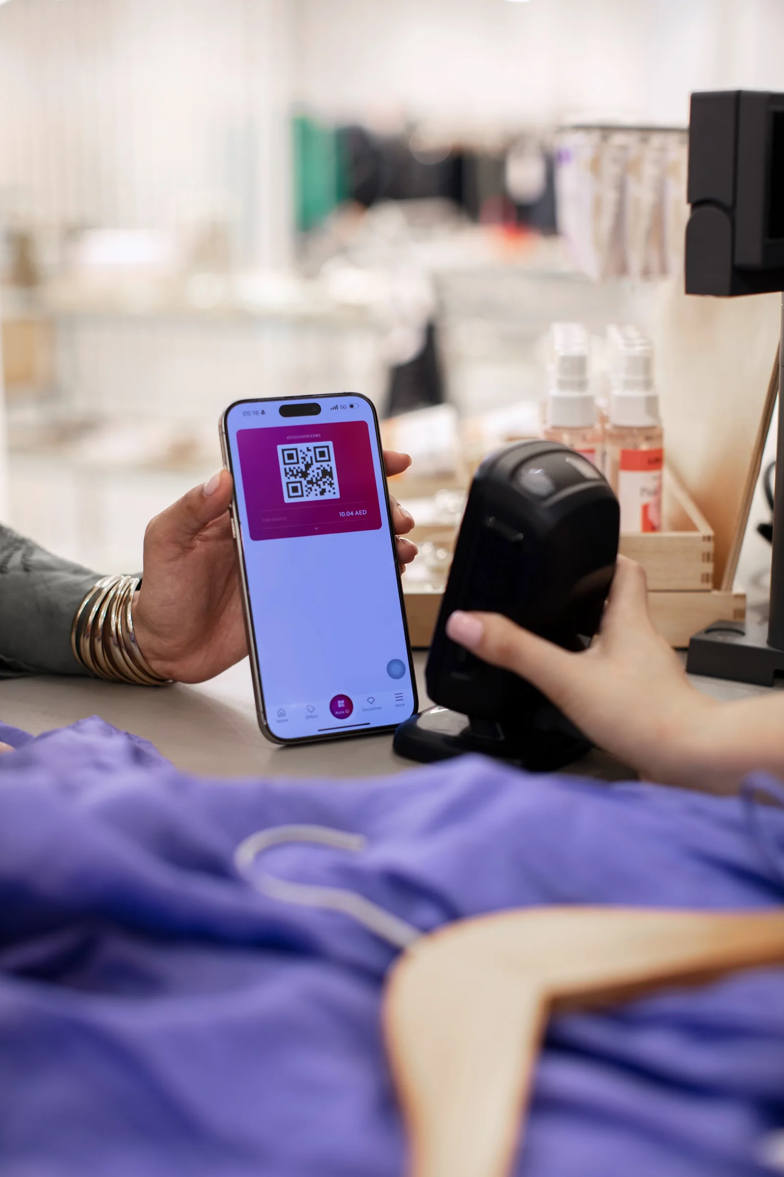 A shopper scans the Aura loyalty pass at checkout in an Alshaya store in the UAE