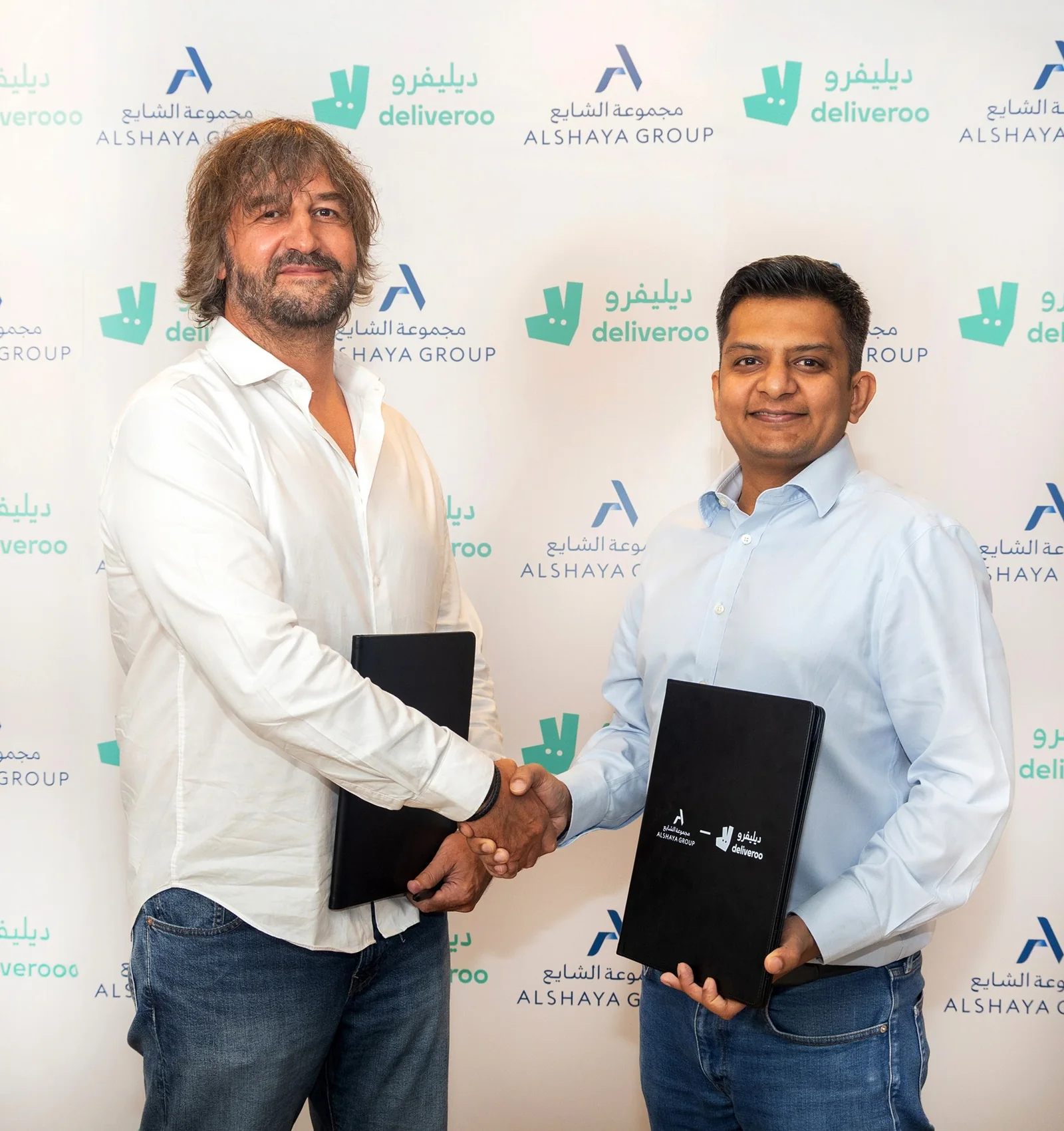 Deliveroo's Prashant Talwar and Alshaya Group's Rob Silsbury shake hands on the brand delivery partnership