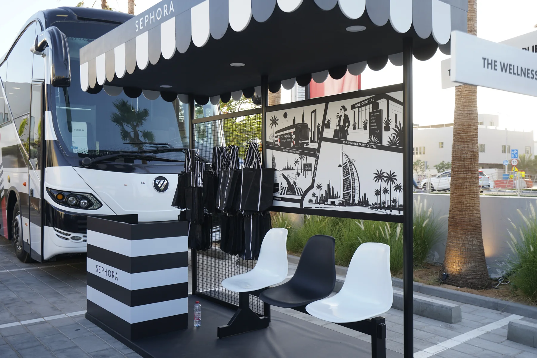 Sephora Beauty on Wheels lounge area in Dubai with striped awning and a black and white photo wall