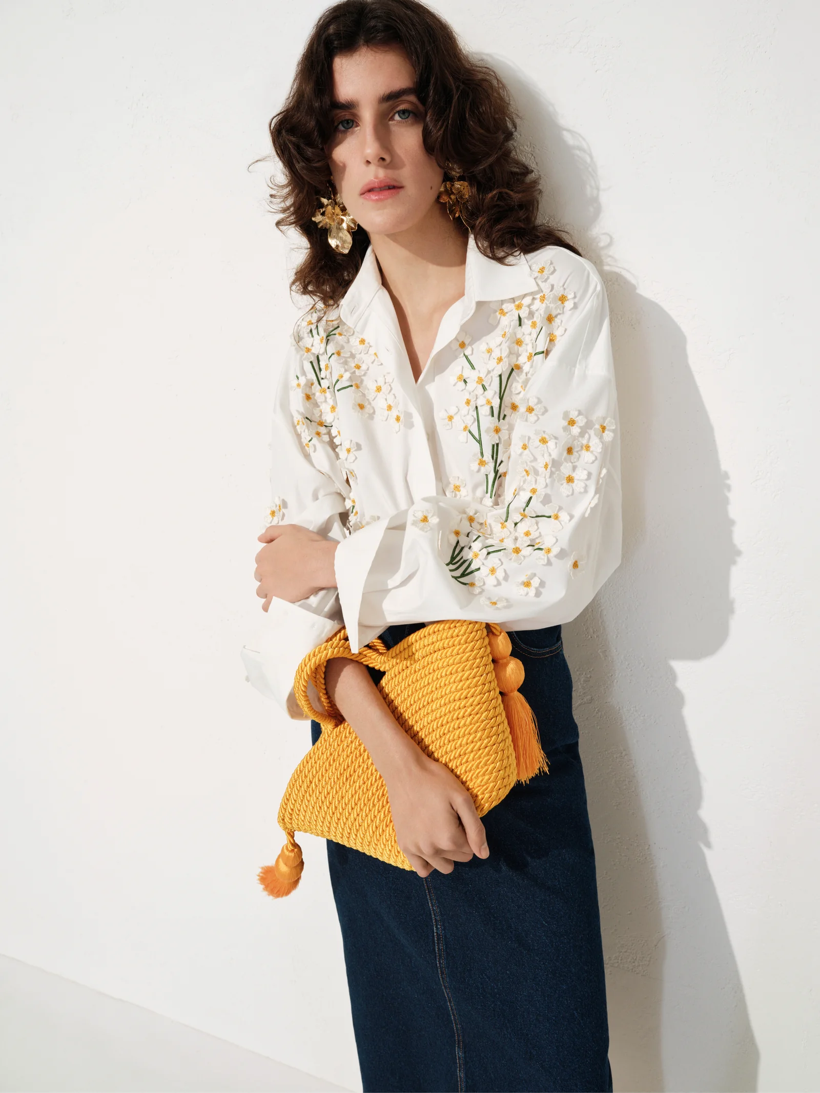 White floral blouse with a yellow crochet bag from Carolina Herrera Resort 2027