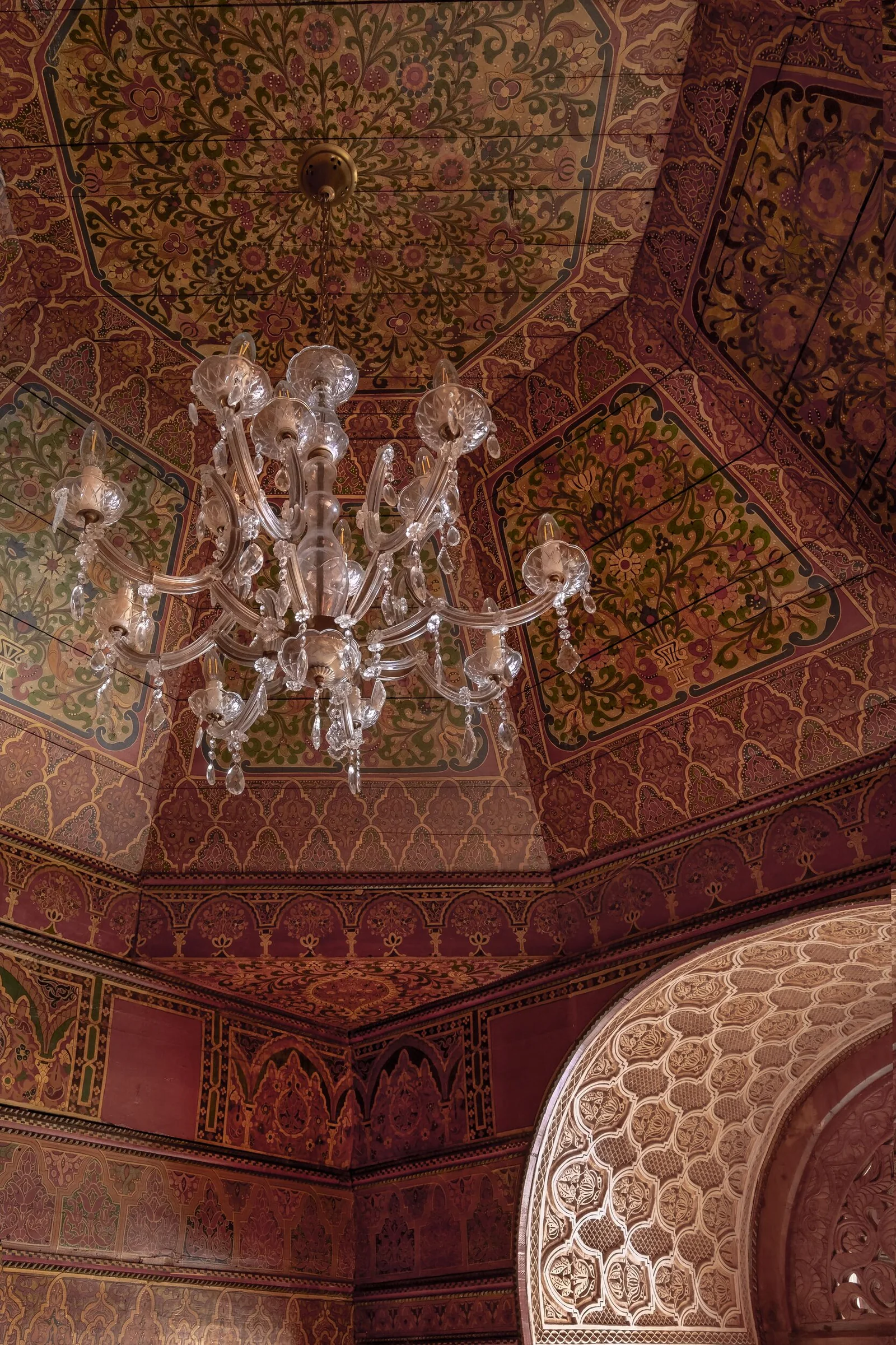 A carved and painted ceiling with a chandelier at La Sultana Marrakech