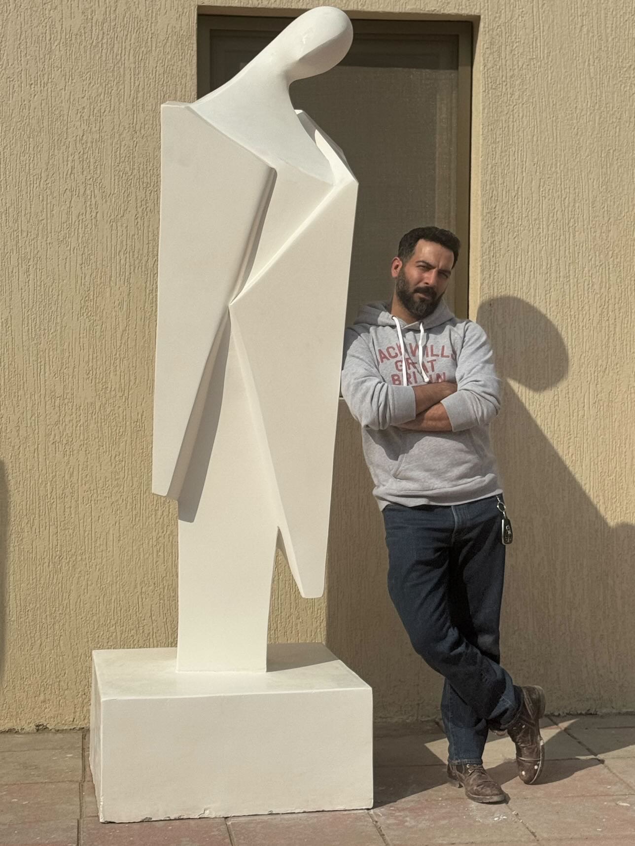 Ahmad Alhussaini beside a sculpture