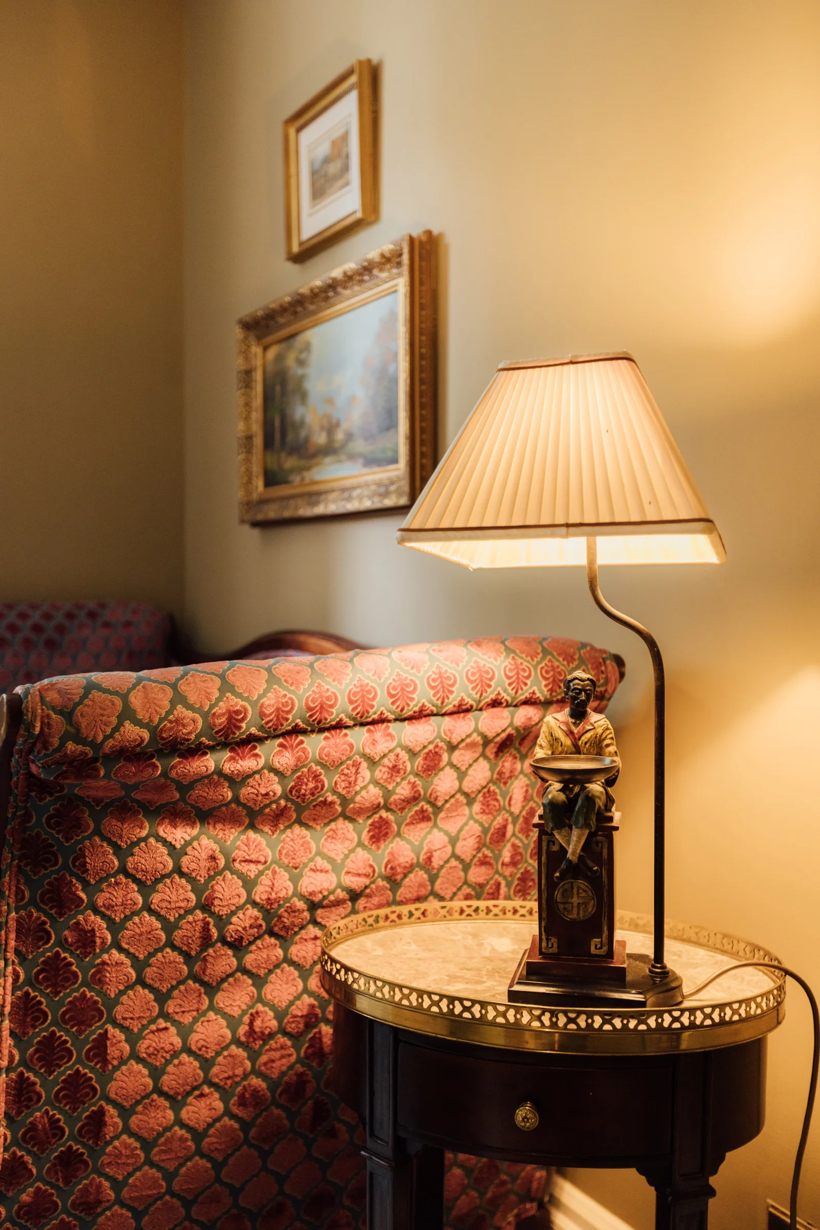 A patterned armchair and lamp in a suite at Roseate House London