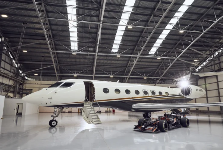 Flexjet Gulfstream private jet parked beside a Formula 1 car, marking the 2026 Flexjet Formula 1 Official Private Aviation Supplier partnership