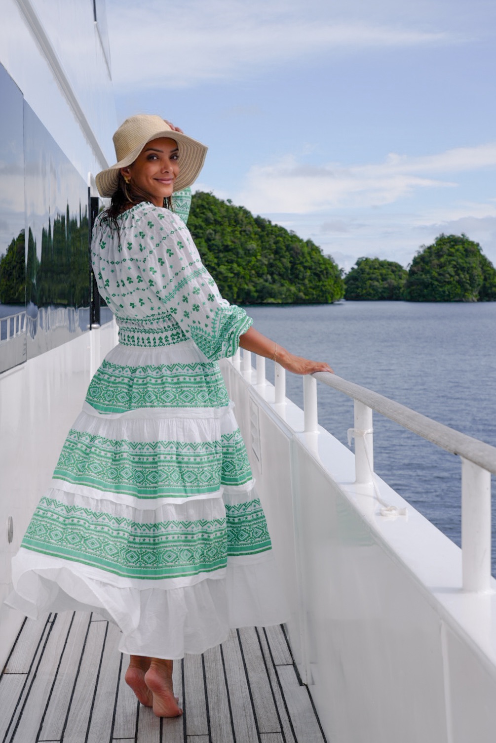 Fatima AlMattar in a green dress on a boat by a lake