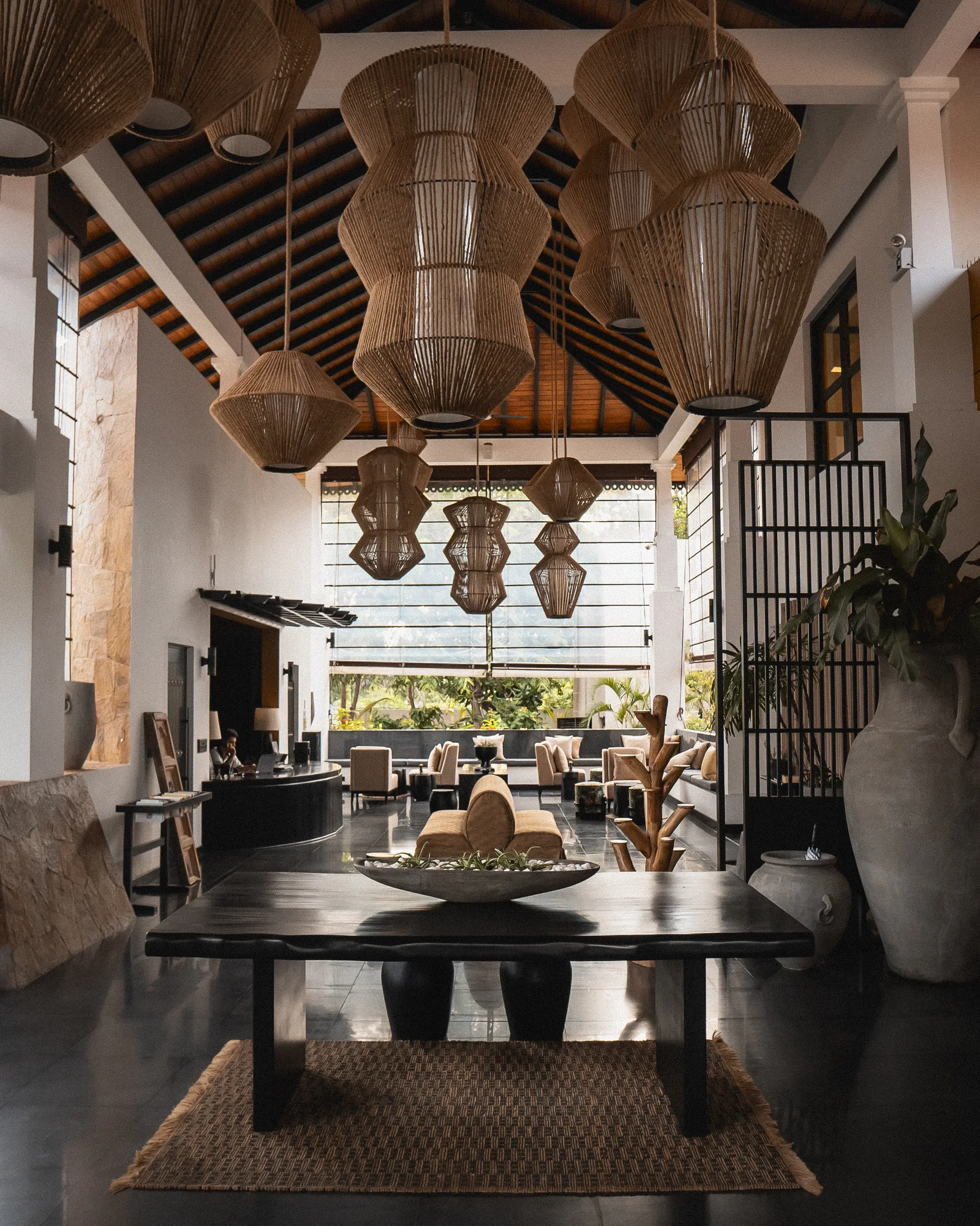 Lobby of Sun Siyam Pasikudah, Sri Lanka, with hand-woven rattan pendant lights and dark timber