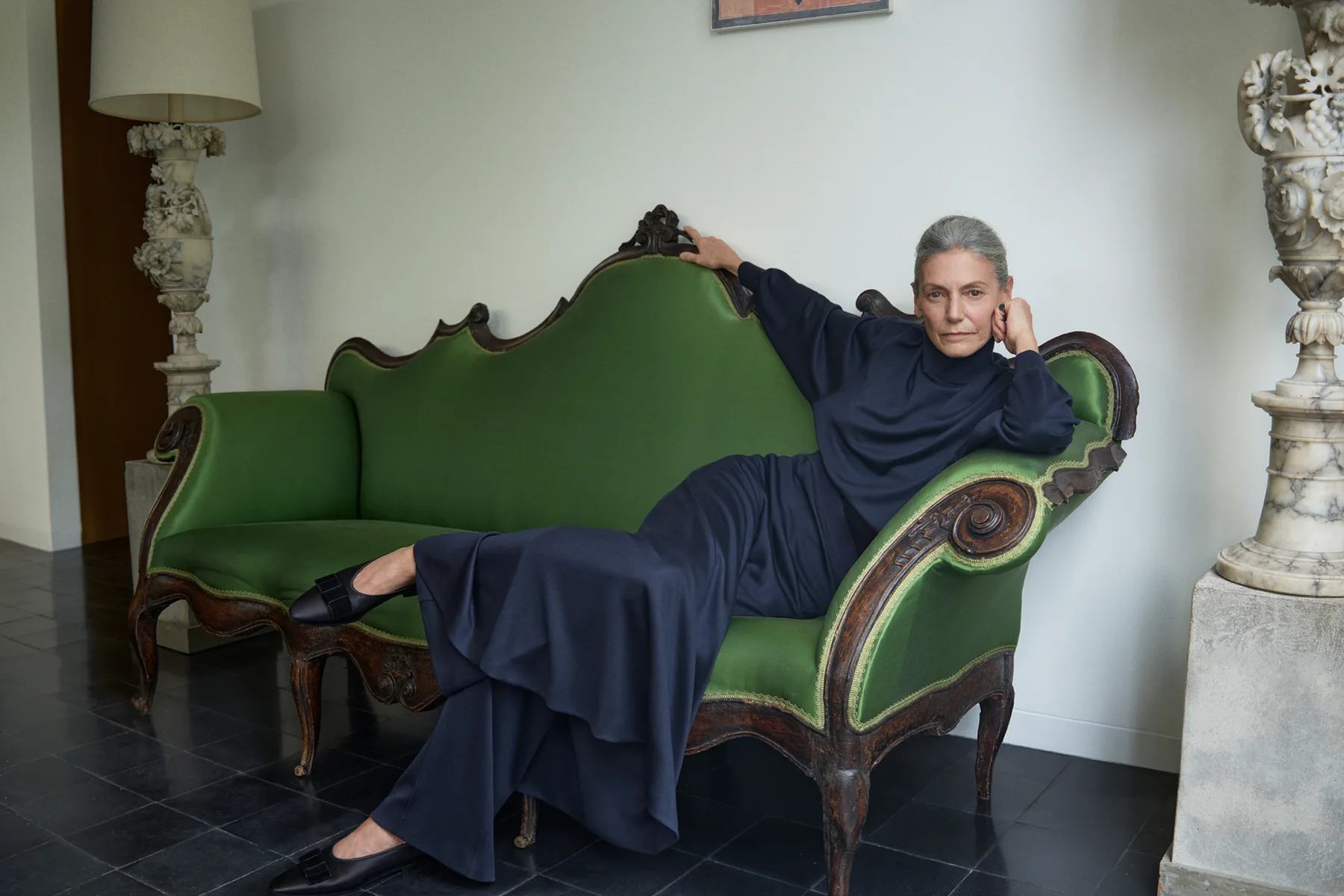 A model reclining on a green velvet sofa in Loro Piana Fall Winter 2026-2027, photographed by Mario Sorrenti at the Menil Collection