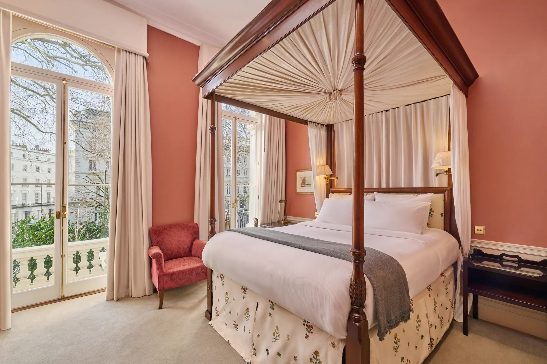 The four-poster bed in a Roseate Suite with balcony at Roseate House London