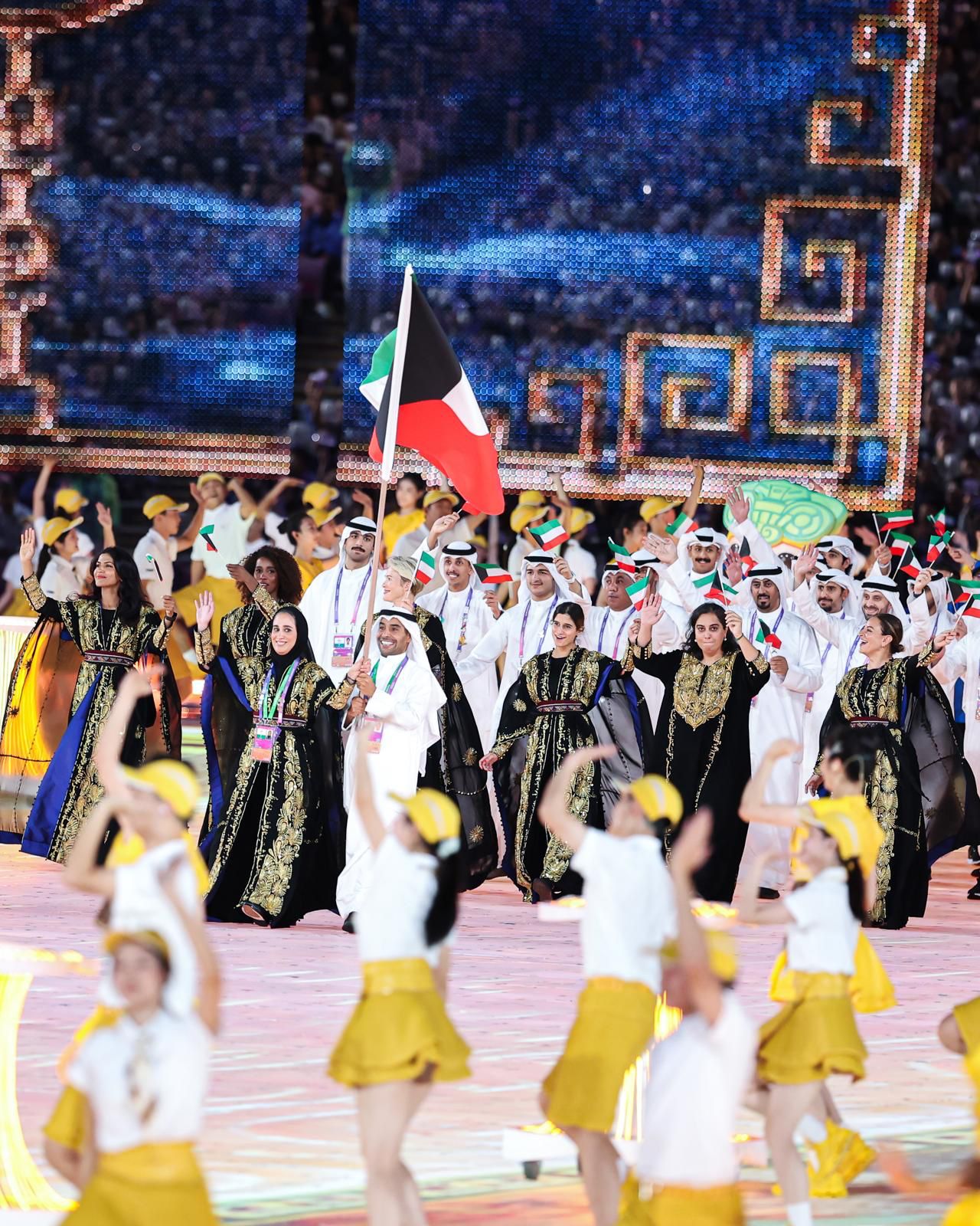 Kuwait's delegation parading in Muhra thoubs behind the national flag at the Olympic ceremony