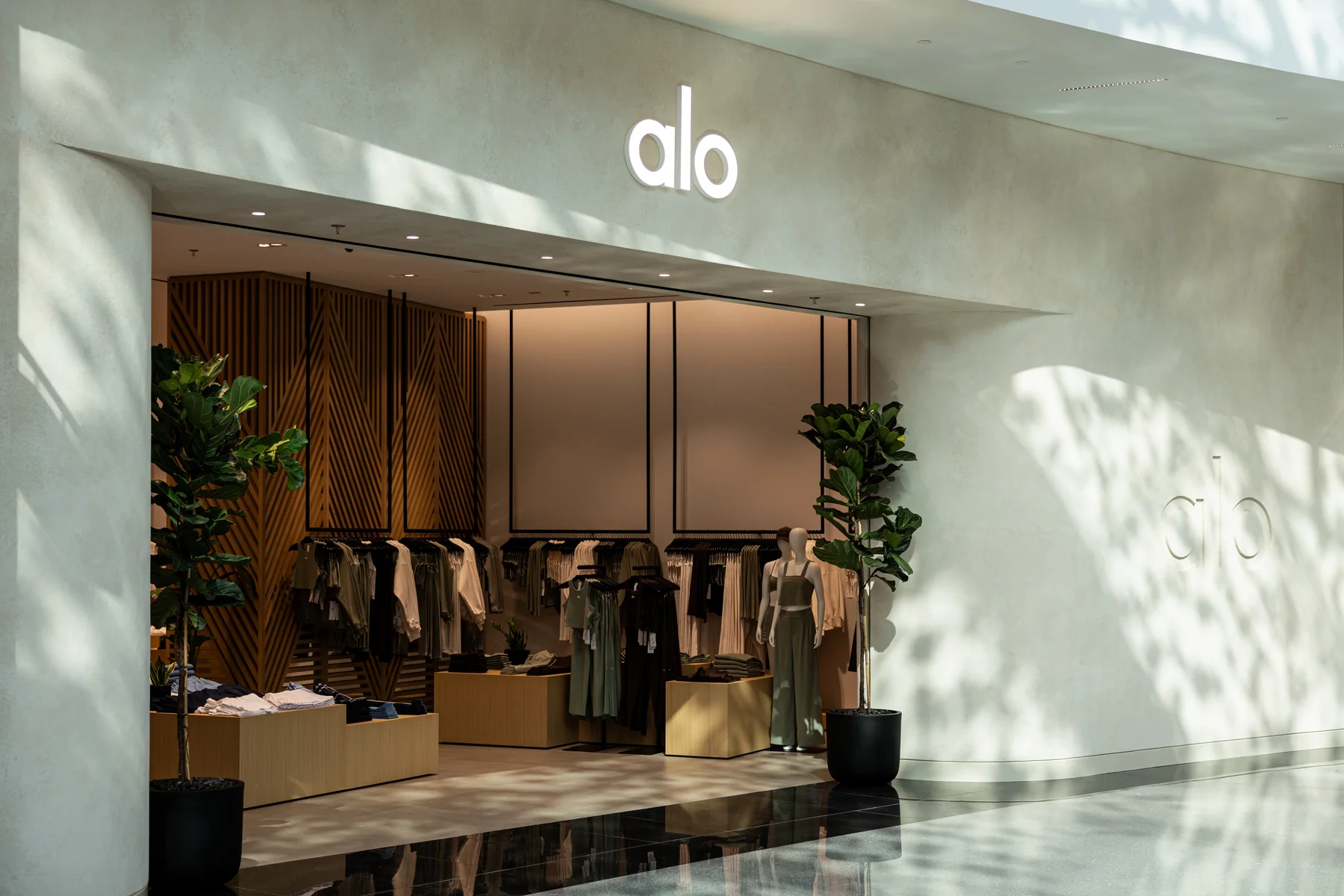 ALO store interior with wood detailing and mannequin displays