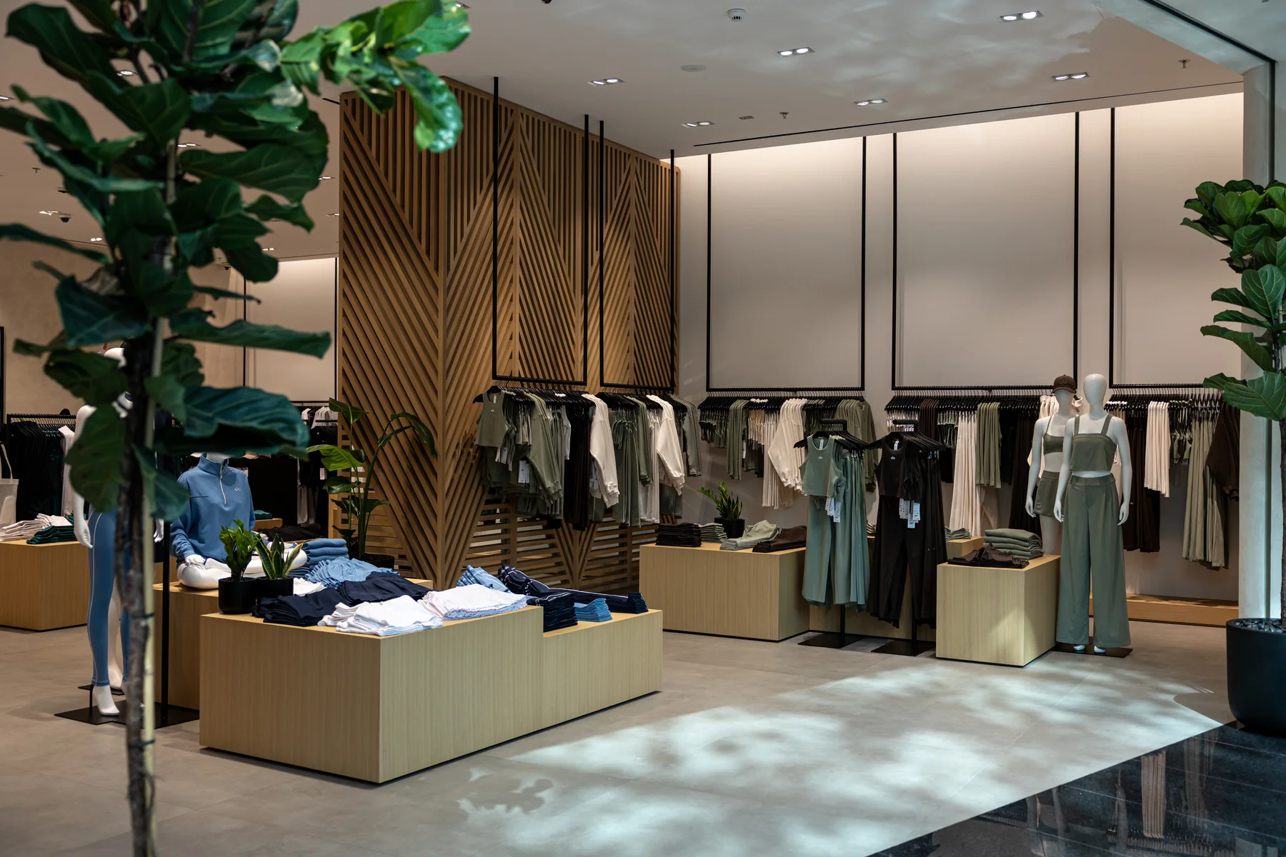 ALO store interior with clothing displays and a potted tree