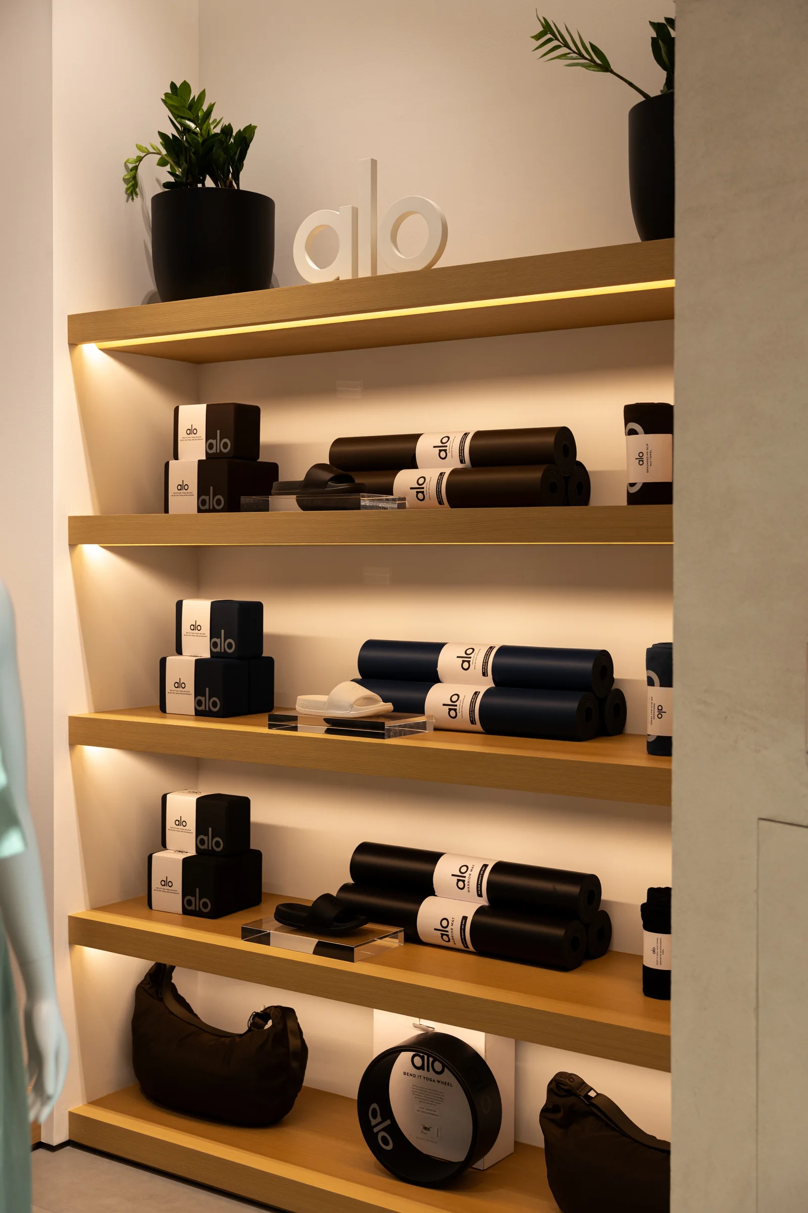 ALO yoga mats, blocks and wellness accessories on shelves