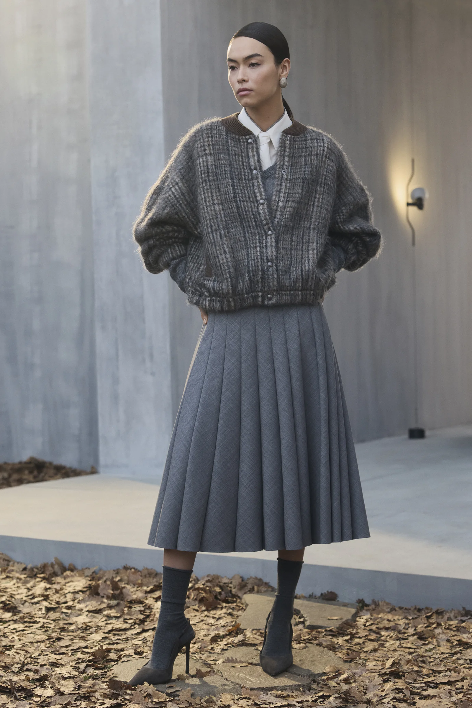 A Brunello Cucinelli tonal knit with a grey pleated midi skirt, Fall Winter 2026