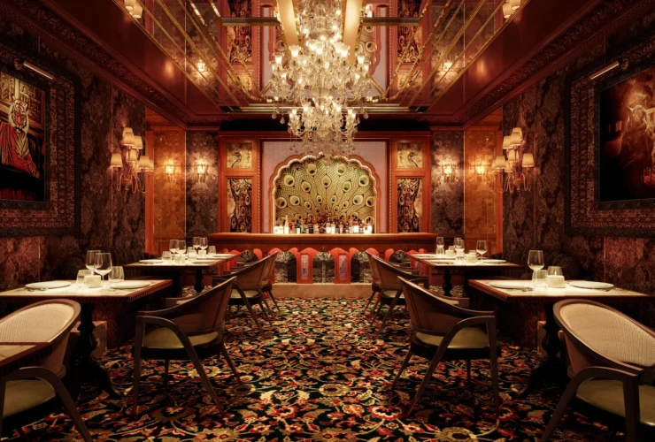The main dining room at Gymkhana Dubai in DIFC, with chandelier, patterned carpet and stained glass