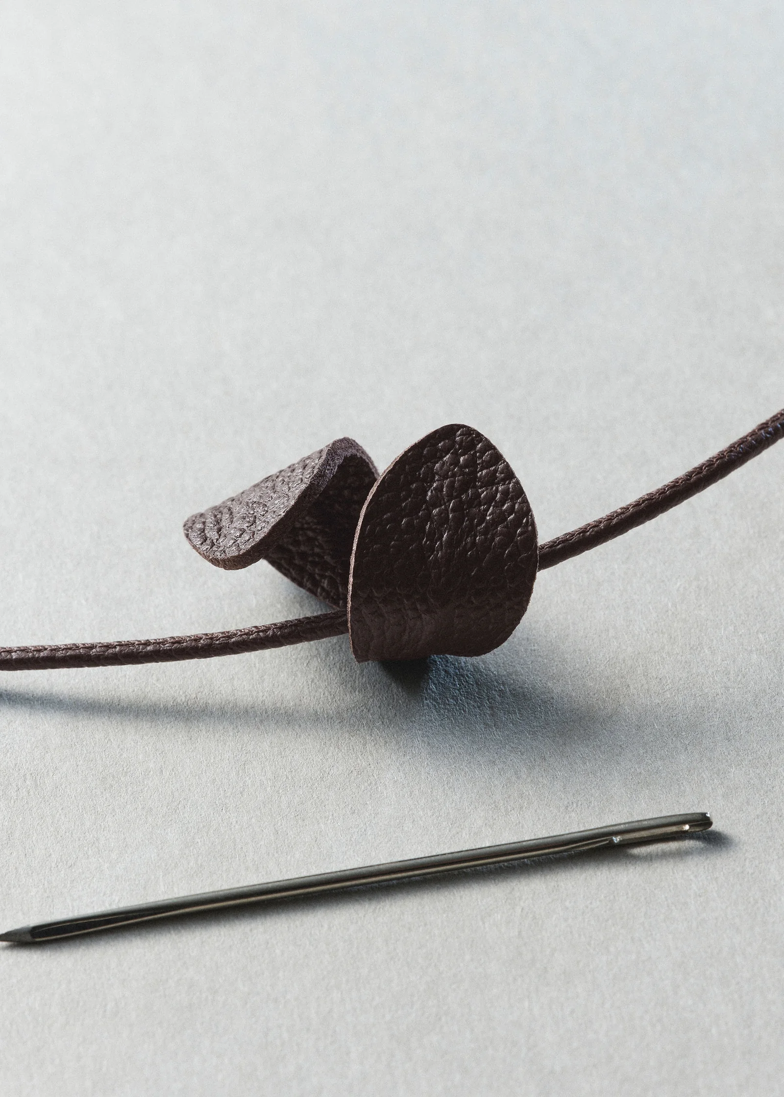 Close detail of the hand-embroidered leather leaves on the Polene Beri Lif