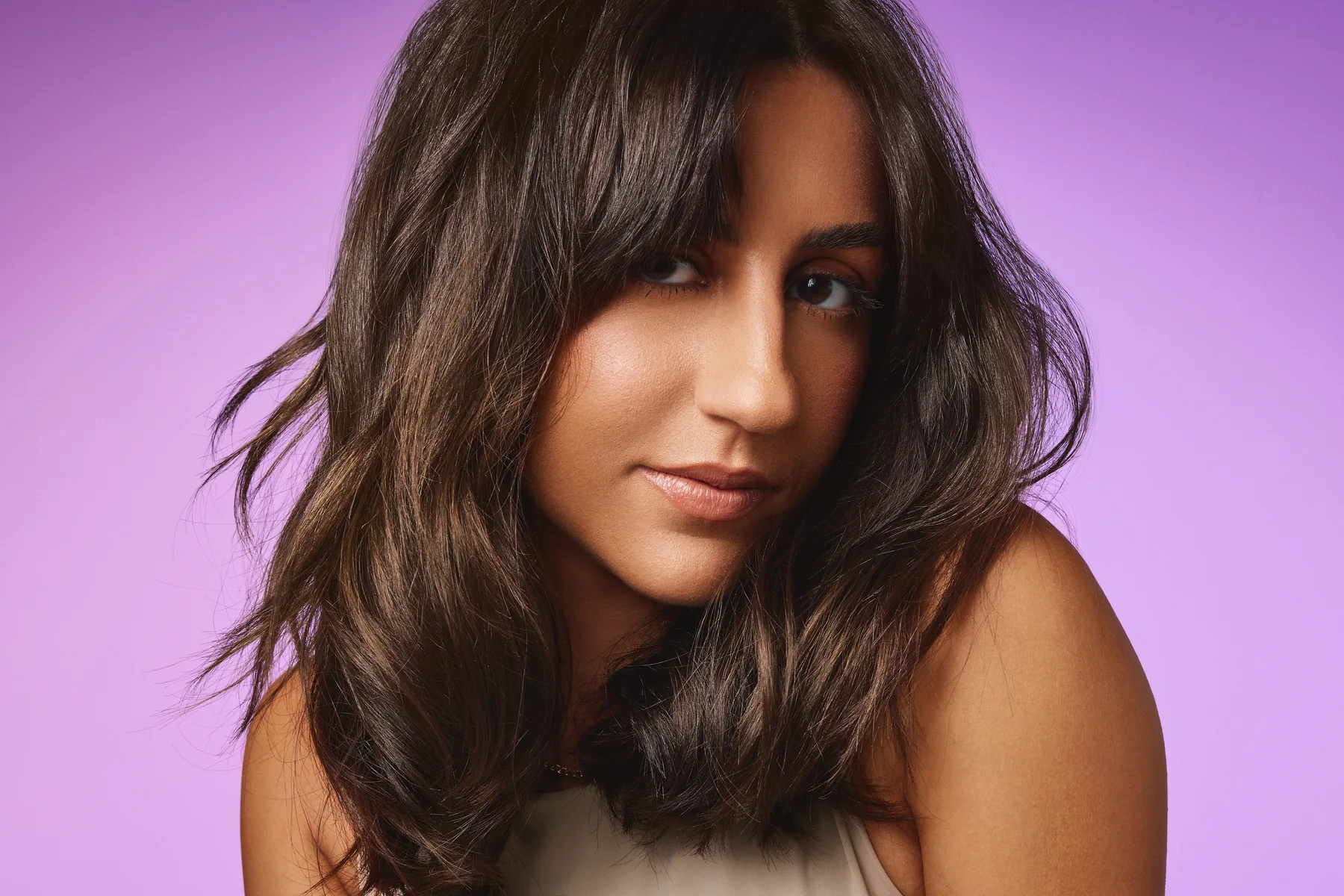 Model with dark wavy hair on a lilac backdrop, Sephora haircare campaign
