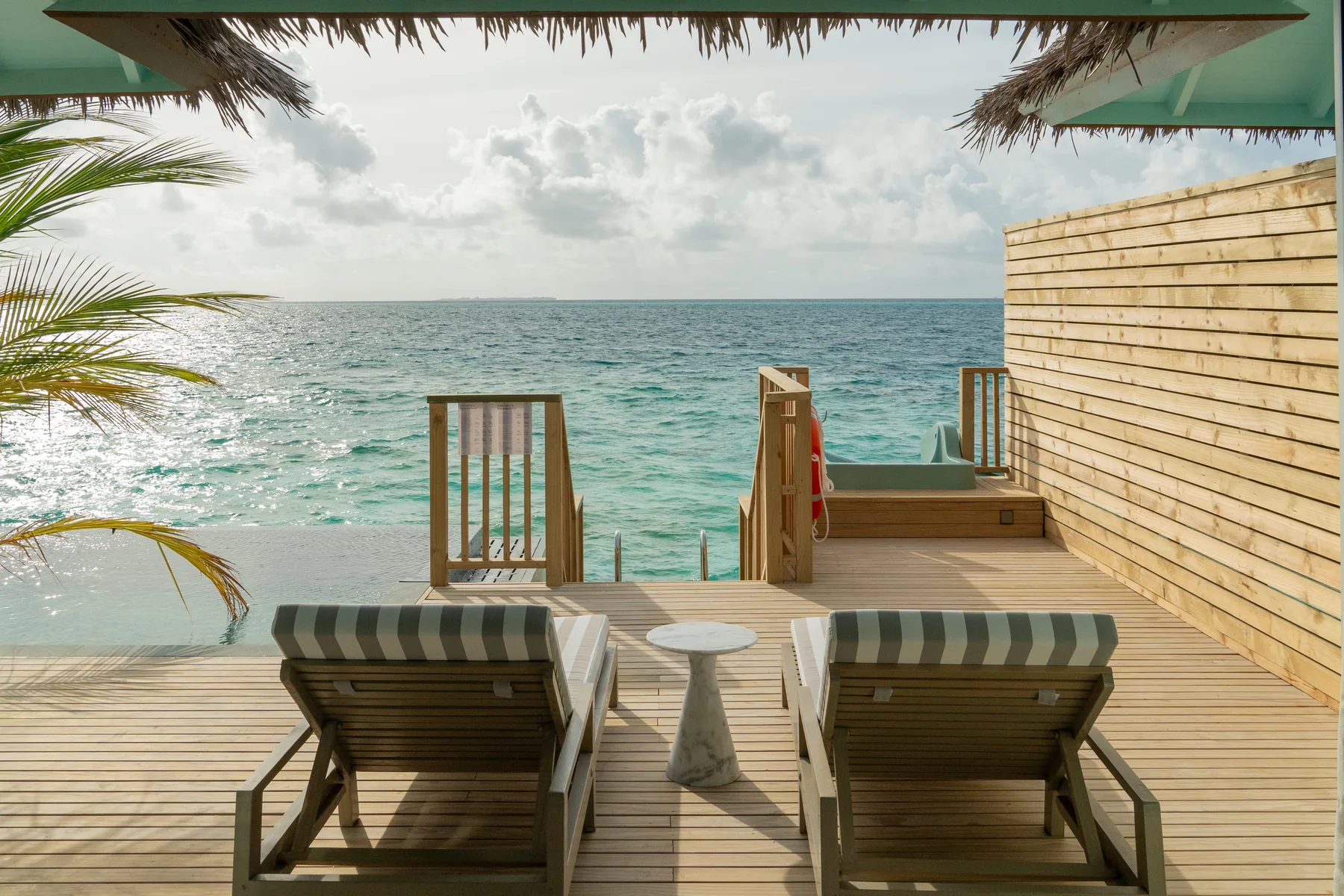 Overwater deck with loungers and ocean view at Sun Siyam Vilu Reef
