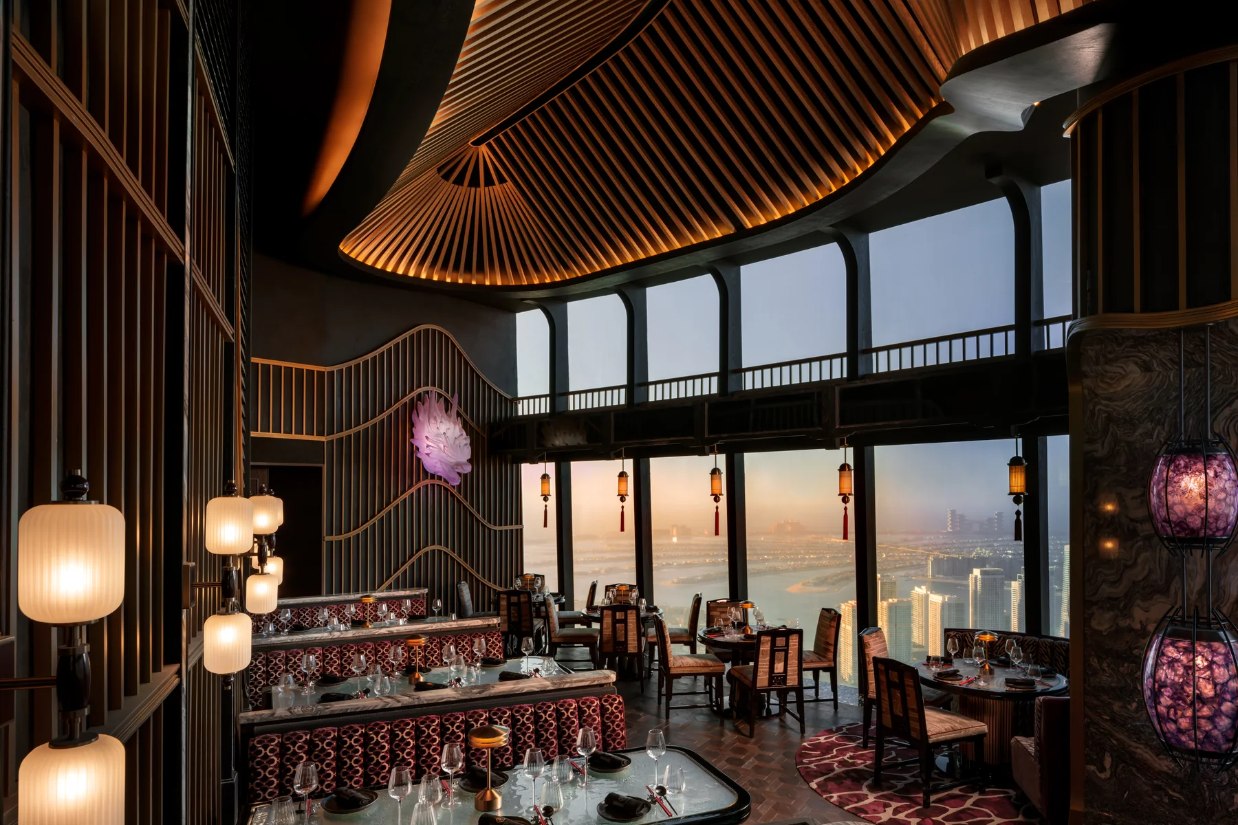 The light-filled dining room at TATTU Restaurant and Bar, Level 74, with views over the Palm at dusk