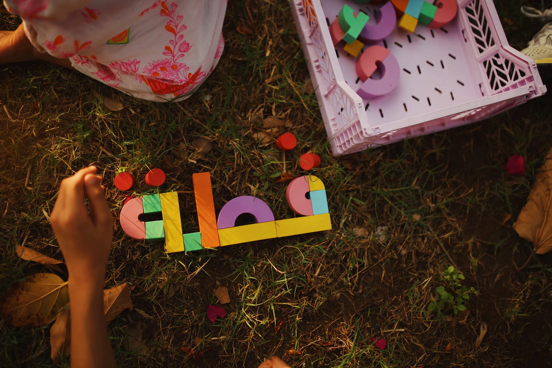 Colourful Akwan letter blocks arranged into an Arabic word on the grass