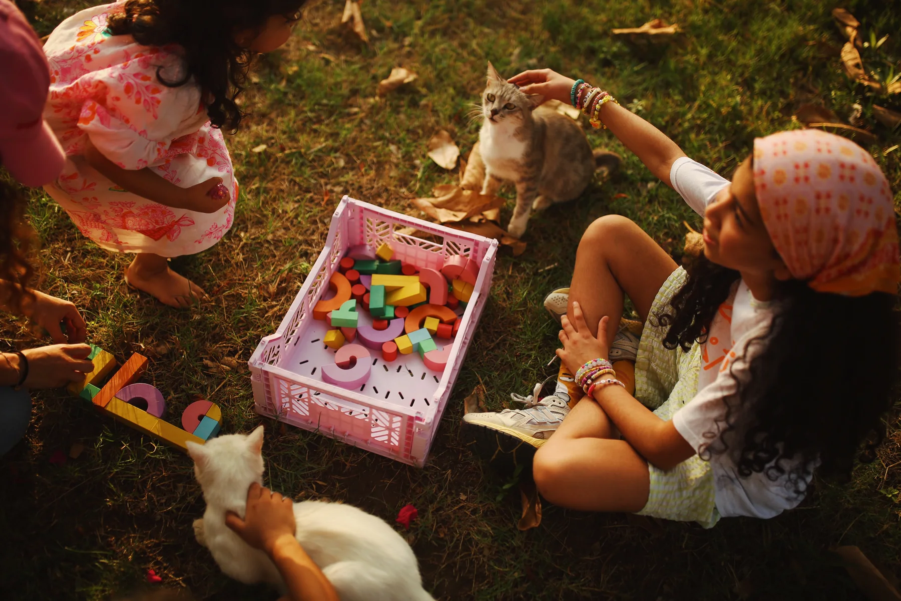 Children and letters spread across a picnic blanket in a park