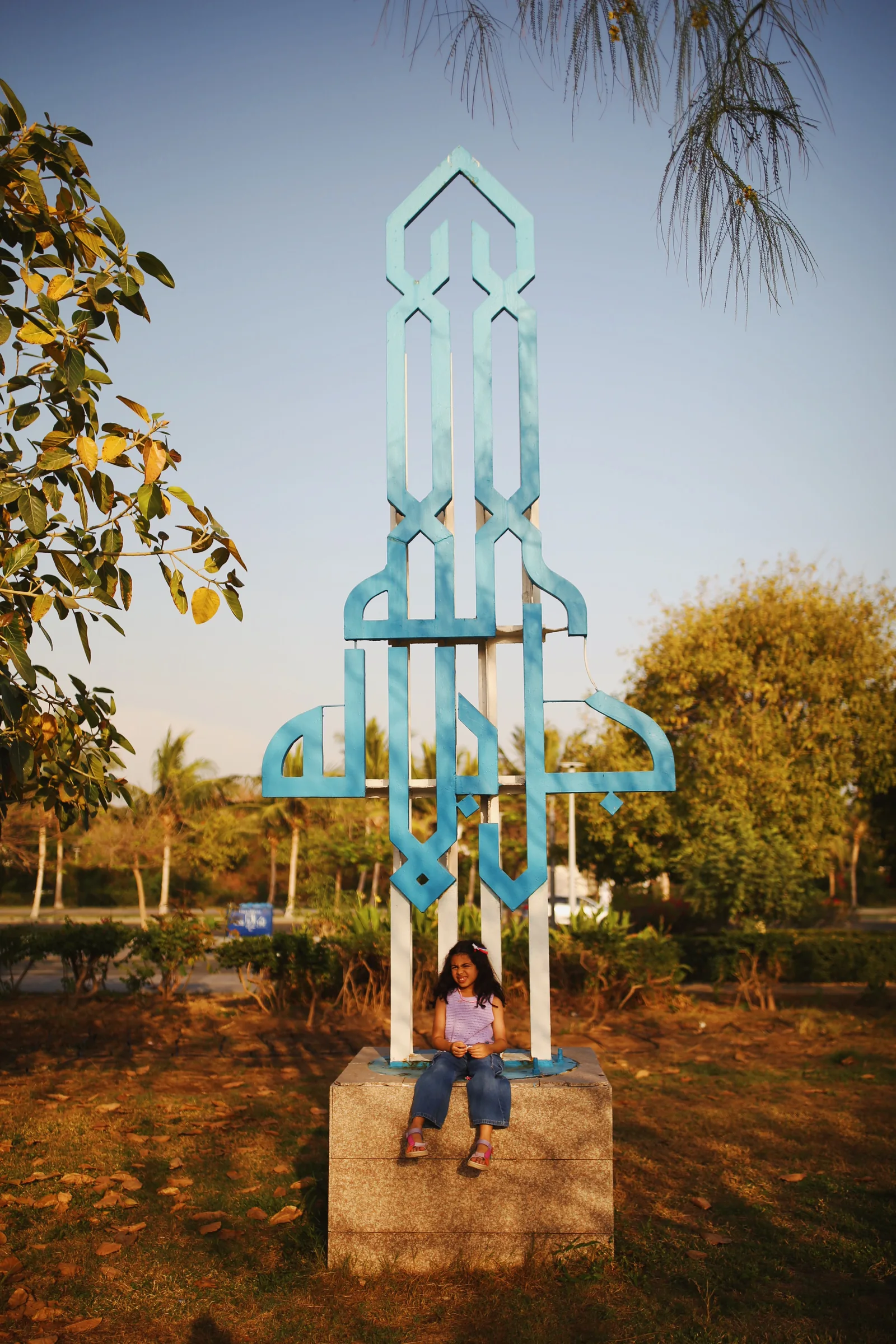 A tall sculpture of Arabic letters standing outdoors