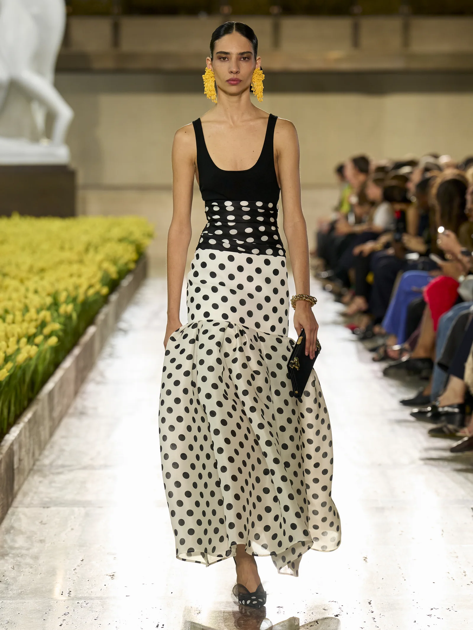 Carolina Herrera Spring 2027 opening look, a black tank and ivory polka-dot drop-waist skirt