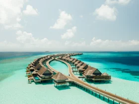 Aerial view of the curved overwater villas at JOALI Maldives