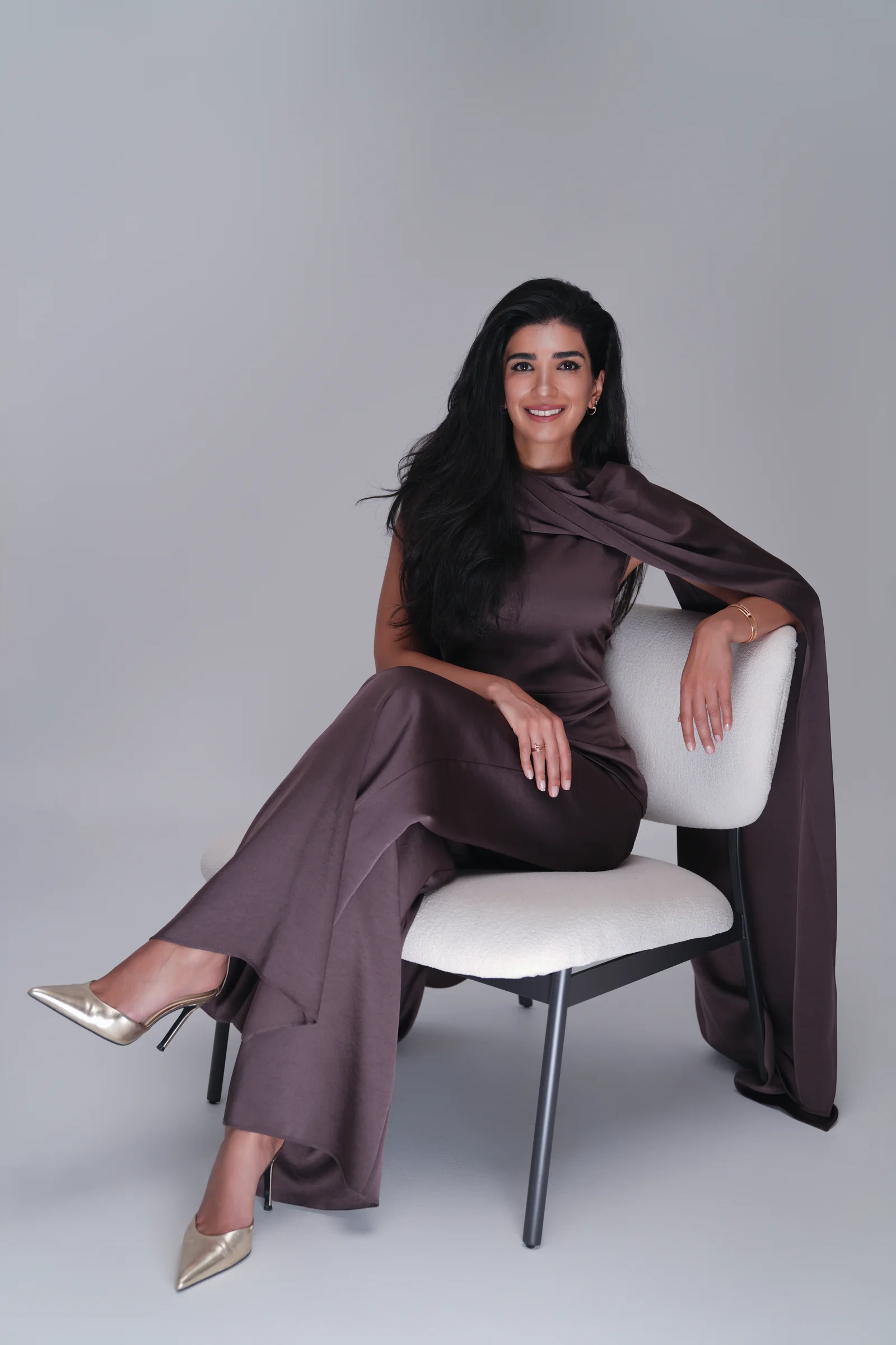 Dr. Noor AlQabandi photographed for Boujeez in a brown satin cape look